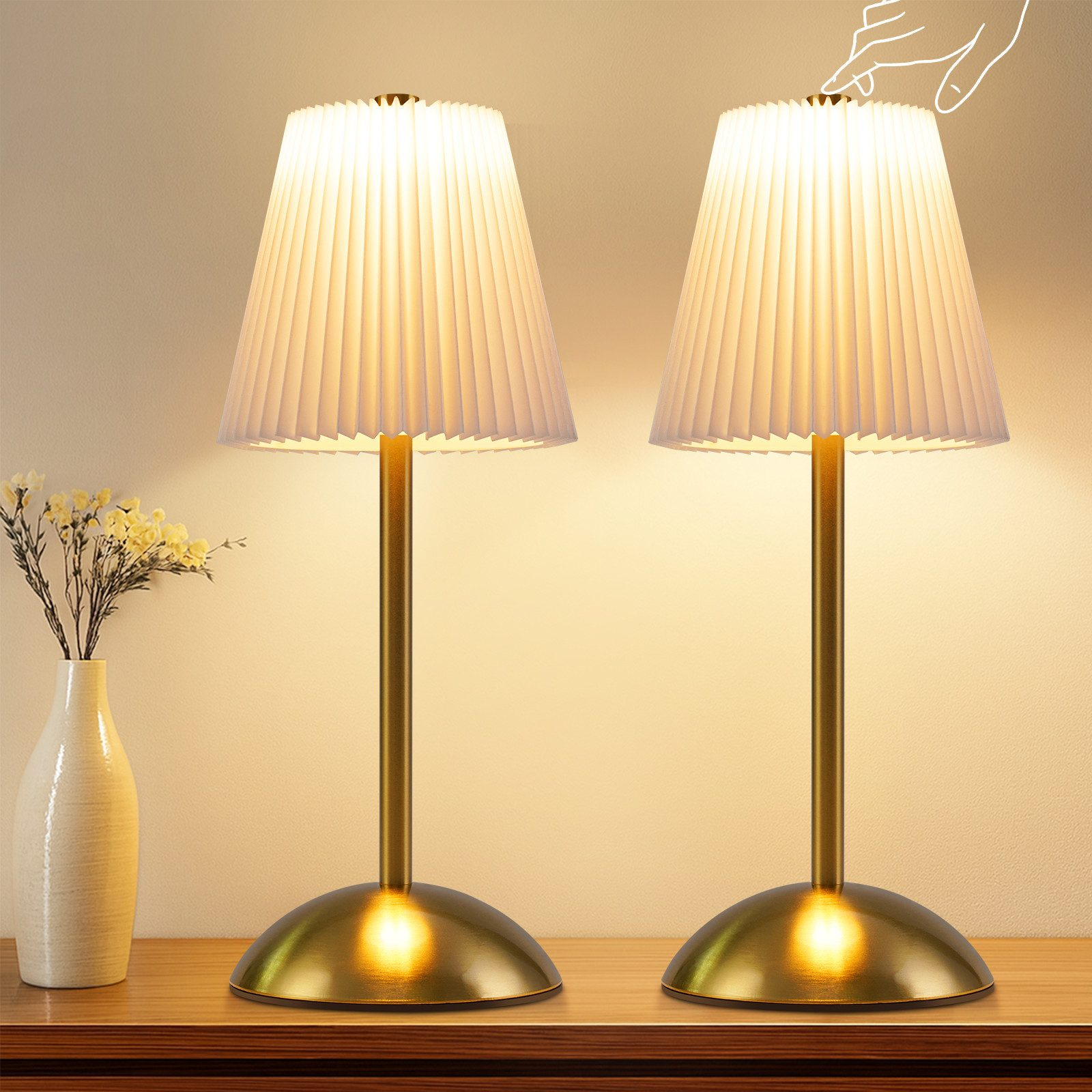 Zwei weiße Faltenlampenschirme mit goldener Basis auf einem Holztisch.