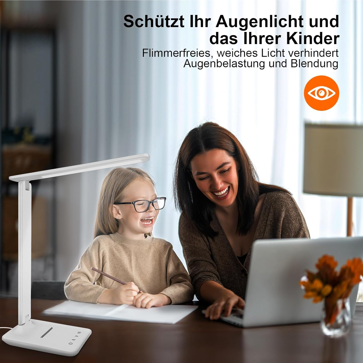 Mutter und Kind lernen am Schreibtisch, beleuchtet von einer Lampe.