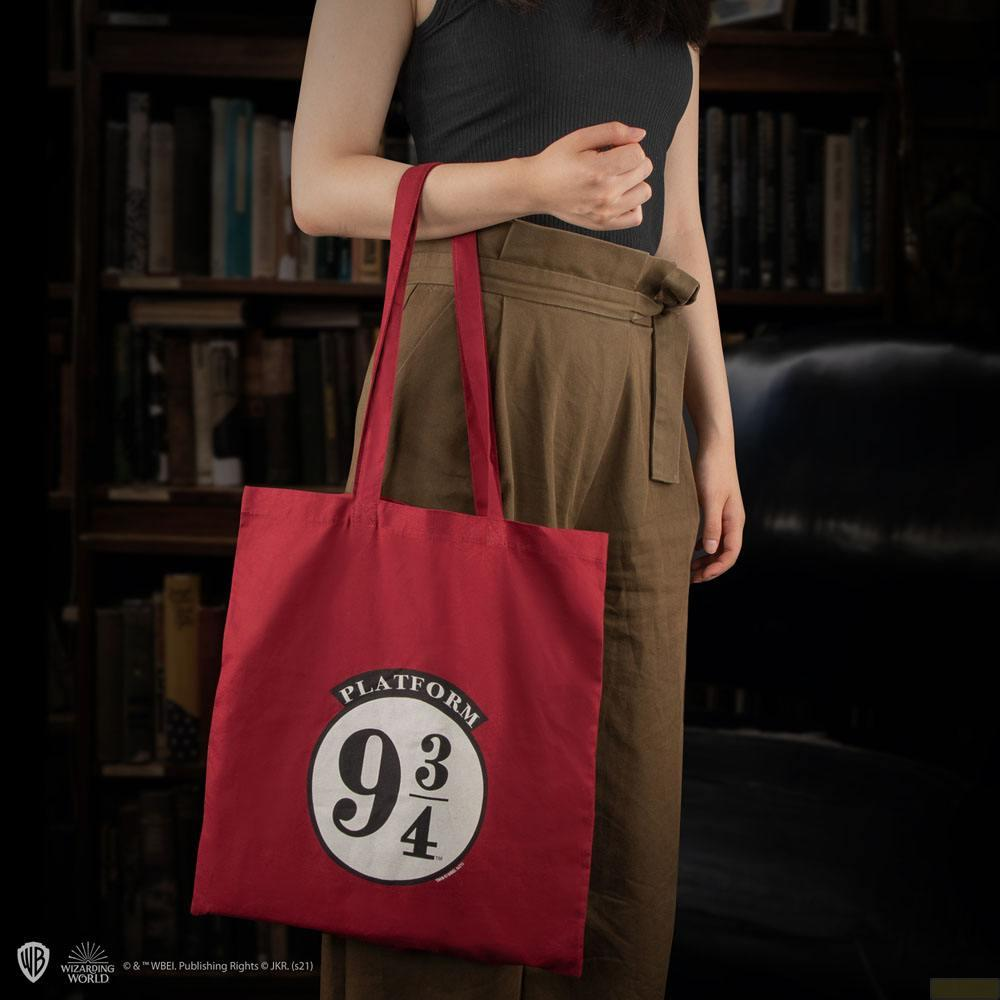 Eine Person hält eine rote Tasche mit der Aufschrift "Platform 9 3/4".