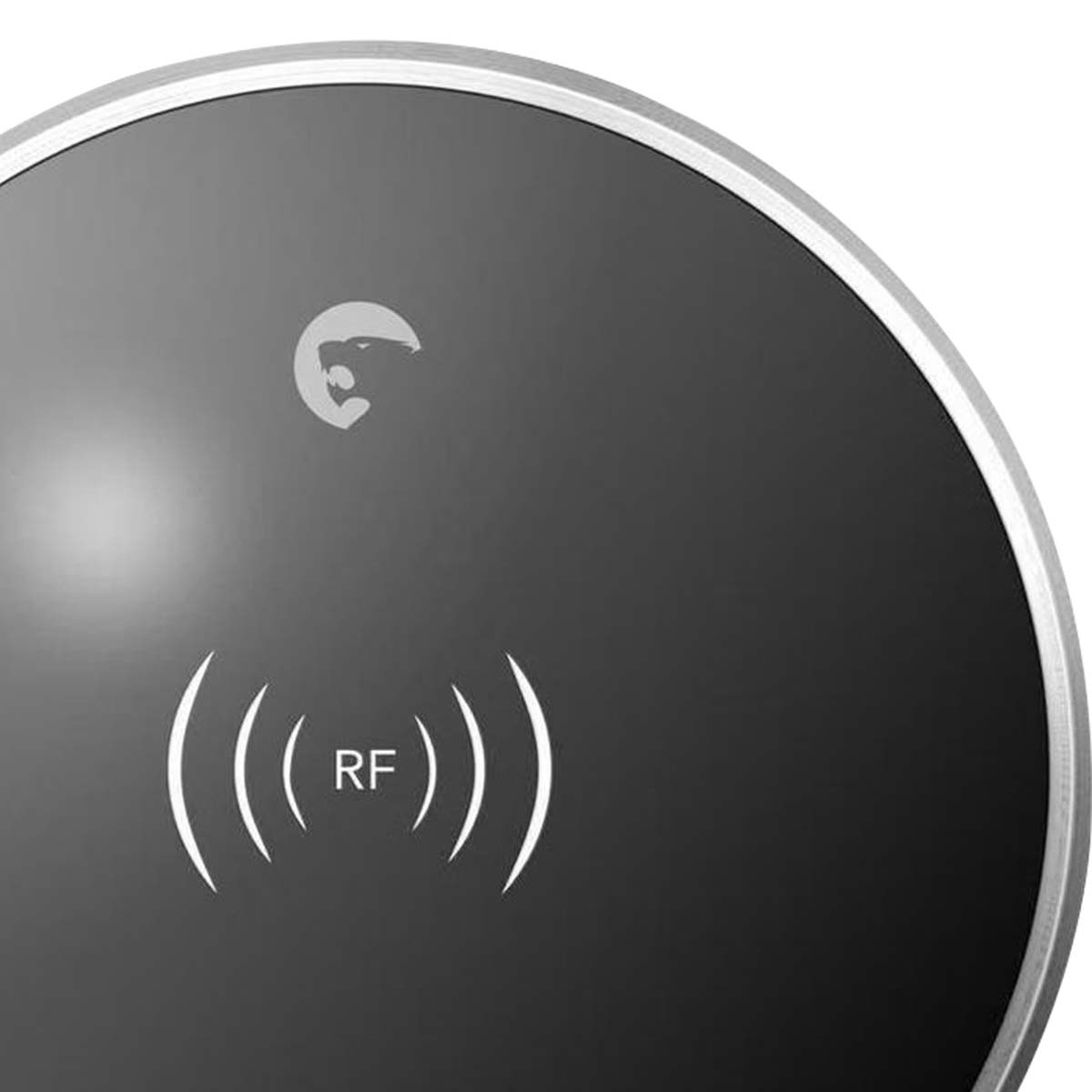 Primo piano di un dispositivo rotondo grigio scuro con bordo argentato, che mostra il simbolo RF.
