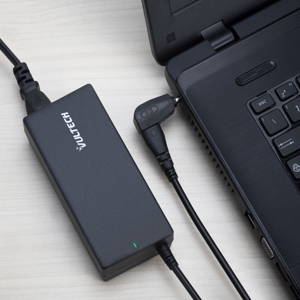 Un alimentatore nero è collegato a un laptop nero.