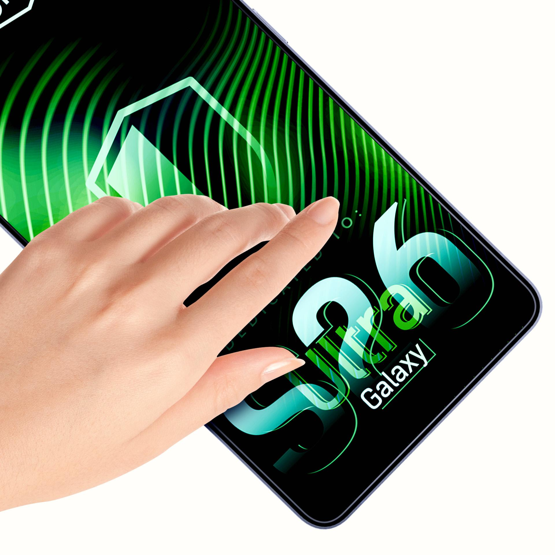 Dłoń dotyka ekranu smartfona z zielonym tłem i napisem.