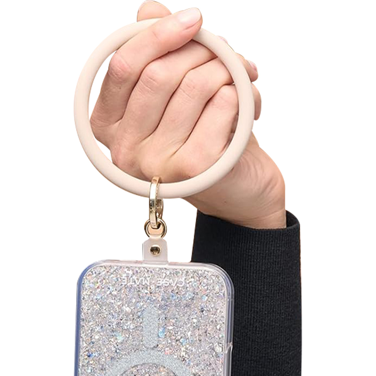 Eine Hand hält einen cremefarbenen Armreif-Schlüsselanhänger mit einer Handyhülle aus Glitzer.