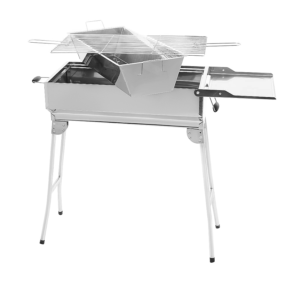 Ein silberner Grill mit ausklappbaren Beinen und Rost.