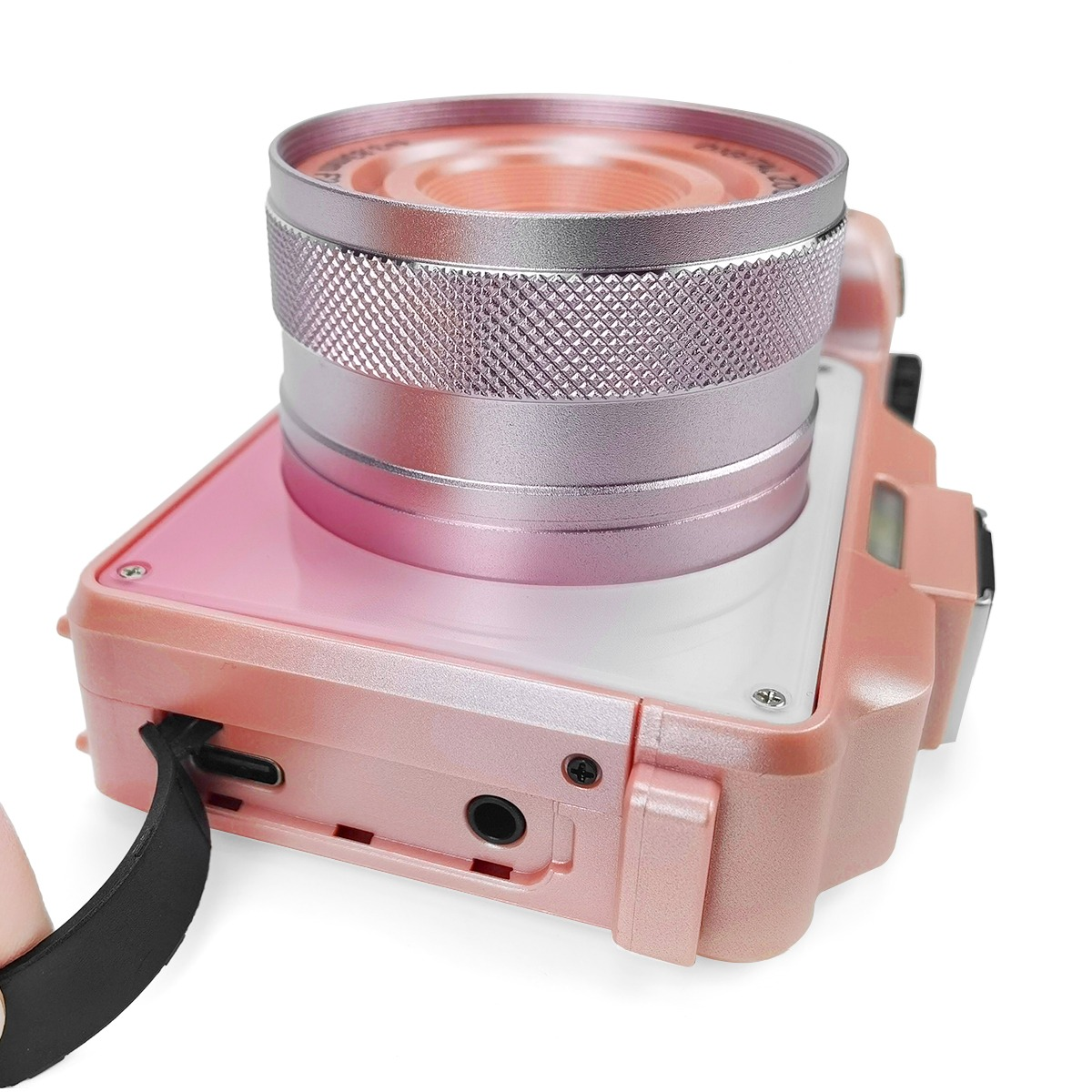 Różowy aparat z srebrnym obiektywem i czarnym mocowaniem paska.