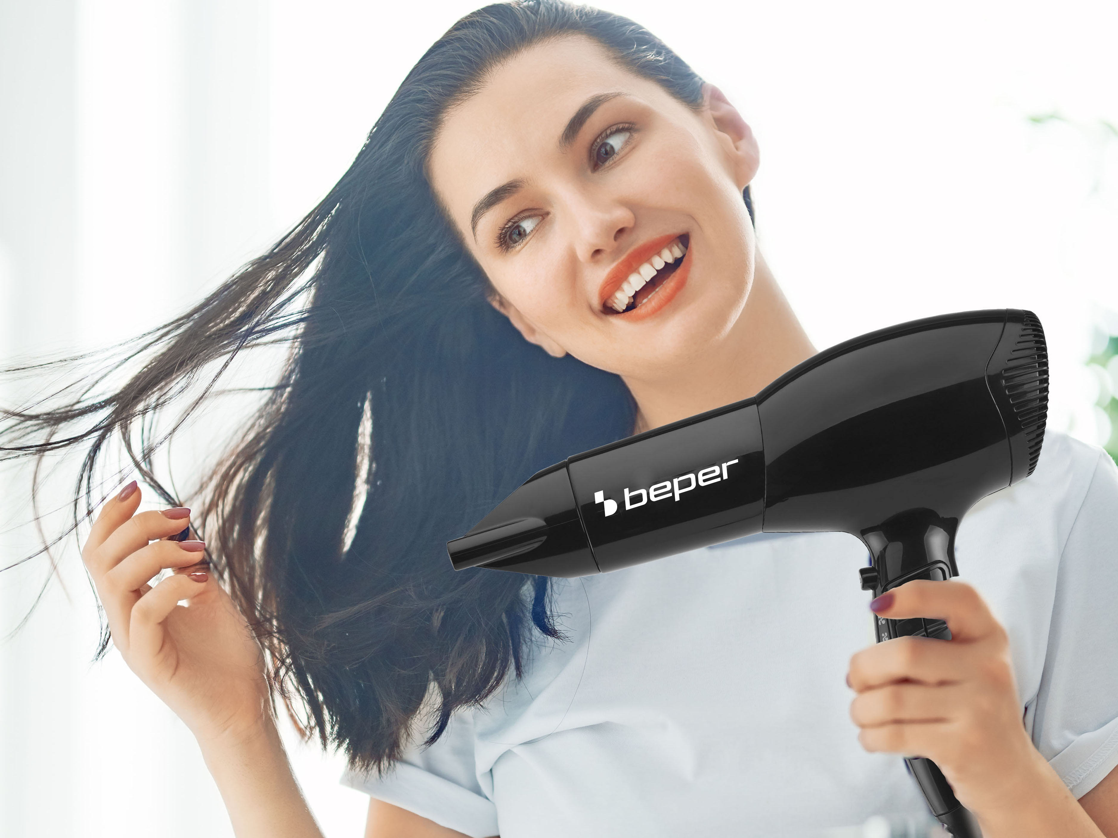 Una donna asciuga i suoi capelli scuri con un asciugacapelli Beper nero.