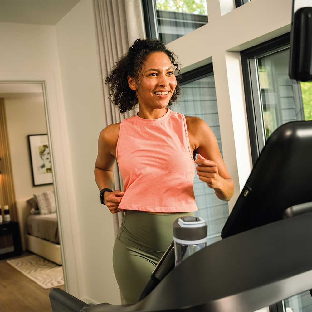 Woman running on a treadmill in a modern home.
