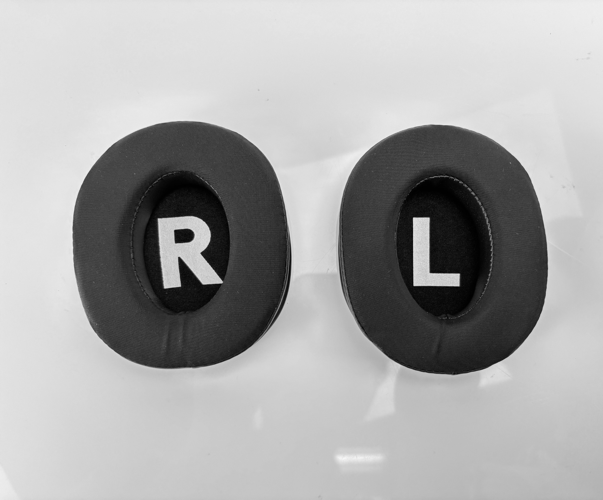 Due cuscinetti neri con lettere R e L bianche.