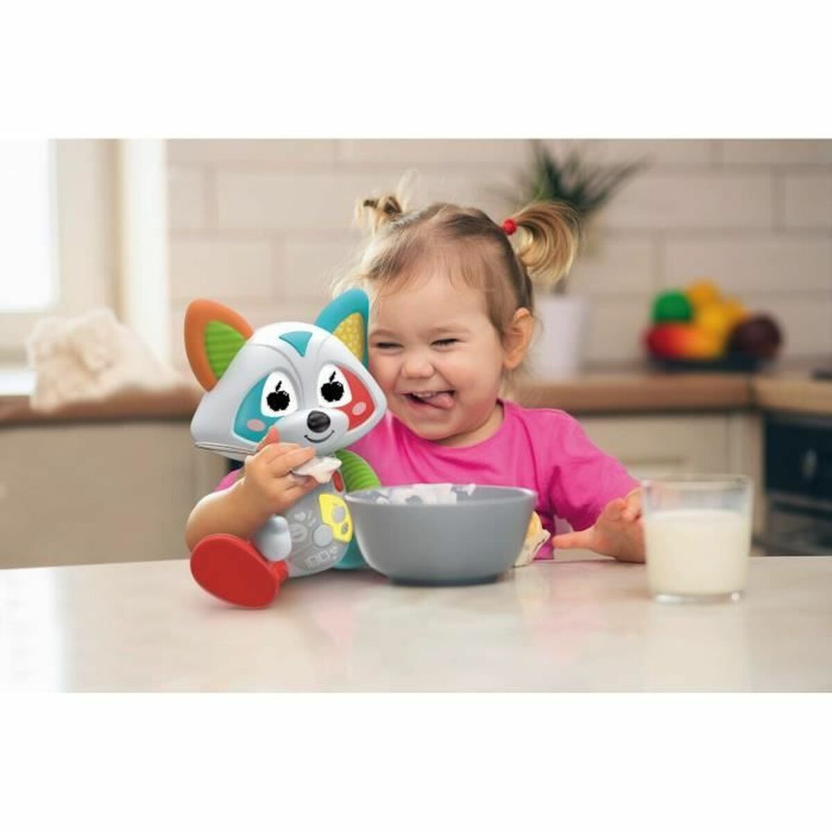 Un bambino mangia con un procione giocattolo a un tavolo da cucina.