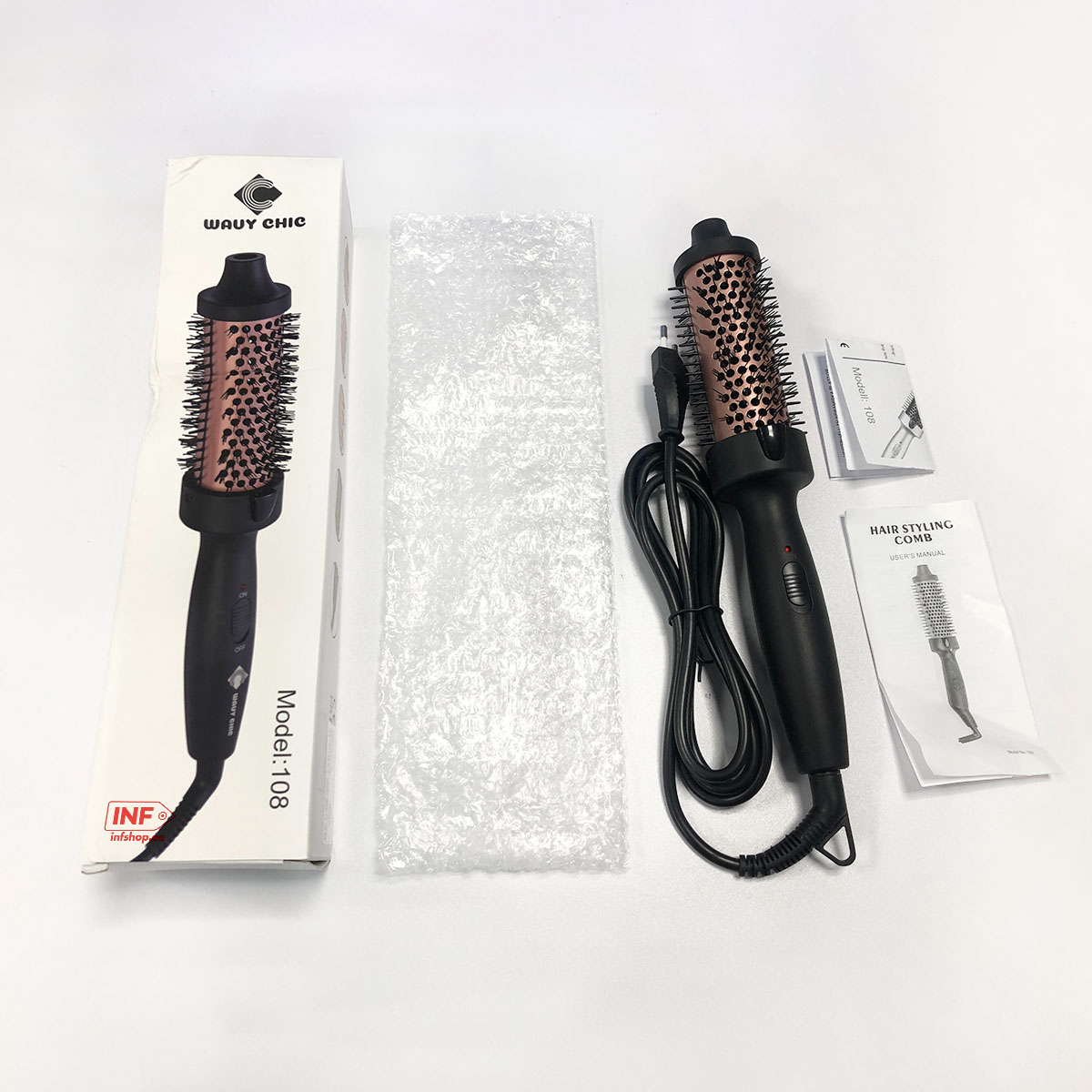A black hair styler with a rose gold barrel, manual, and packaging on a white surface.