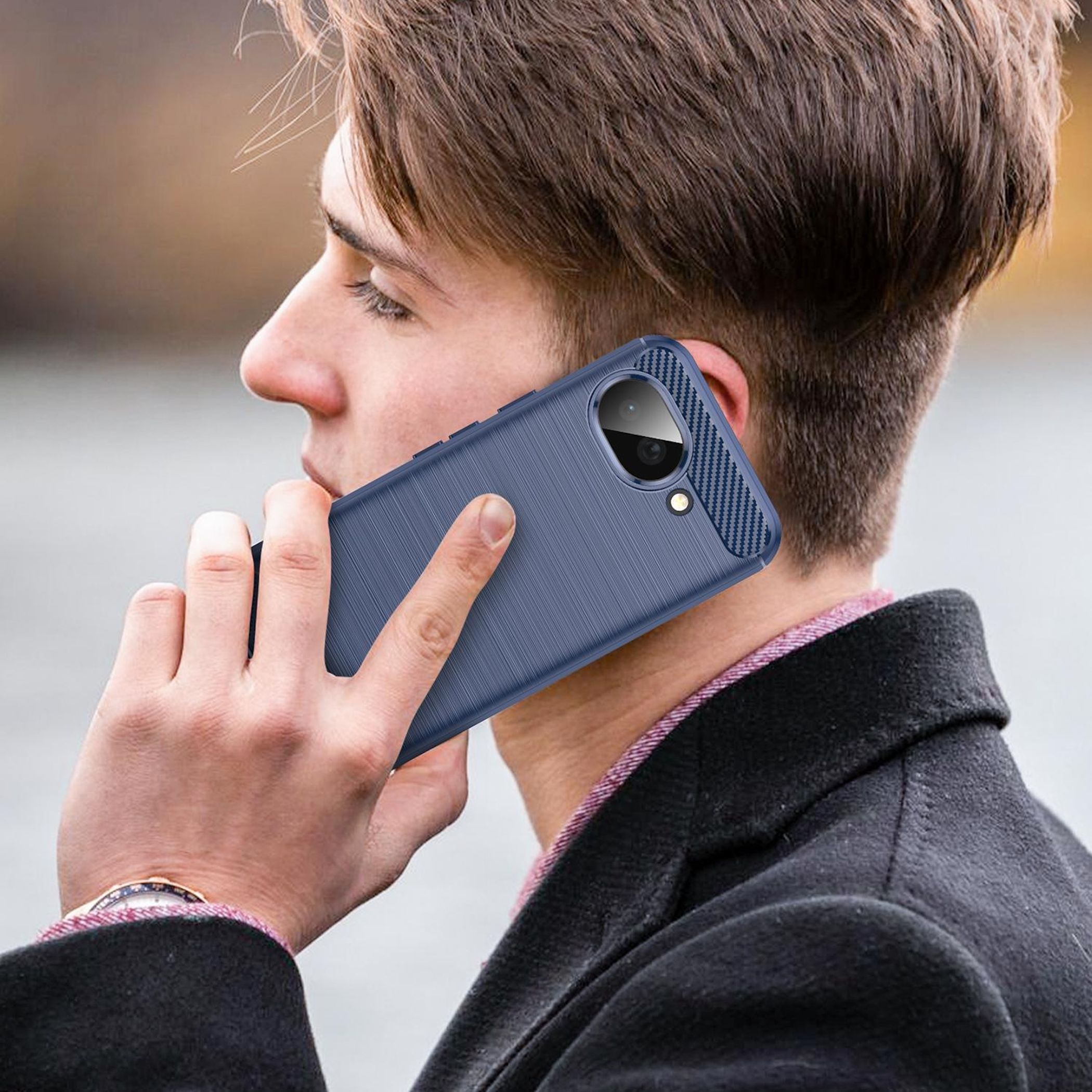 Ein Mann mit blauem Mantel telefoniert mit einem blauen Handy.