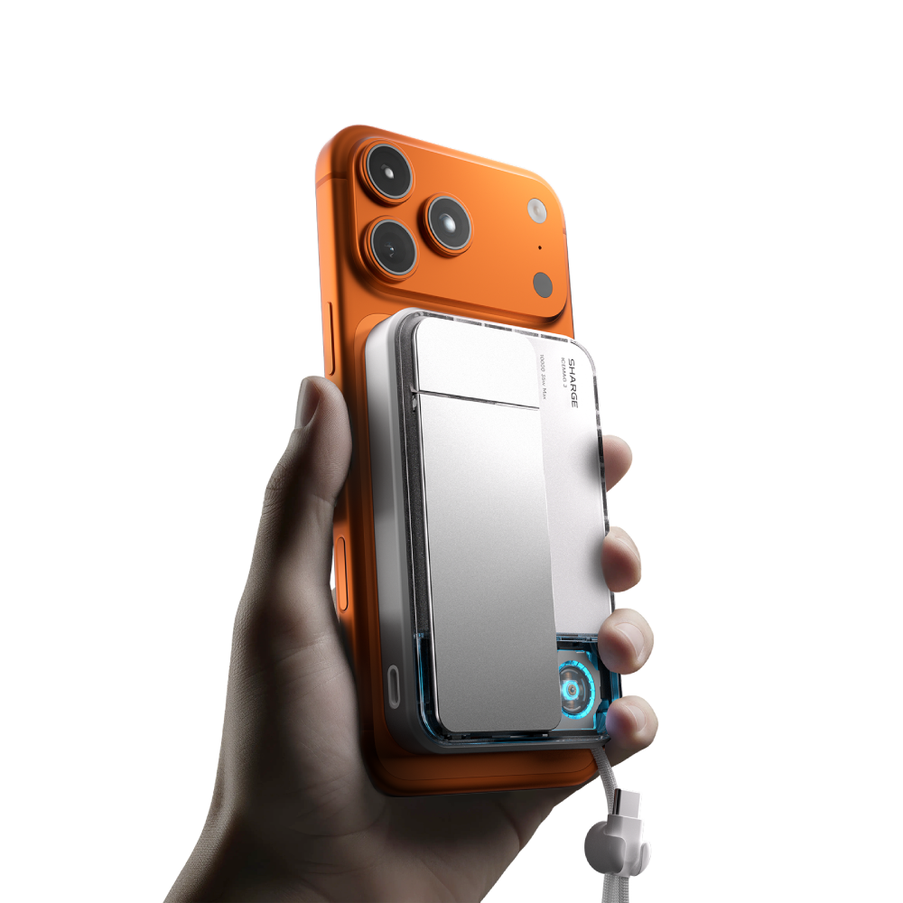 Une main tient un iPhone orange avec une batterie argentée attachée.