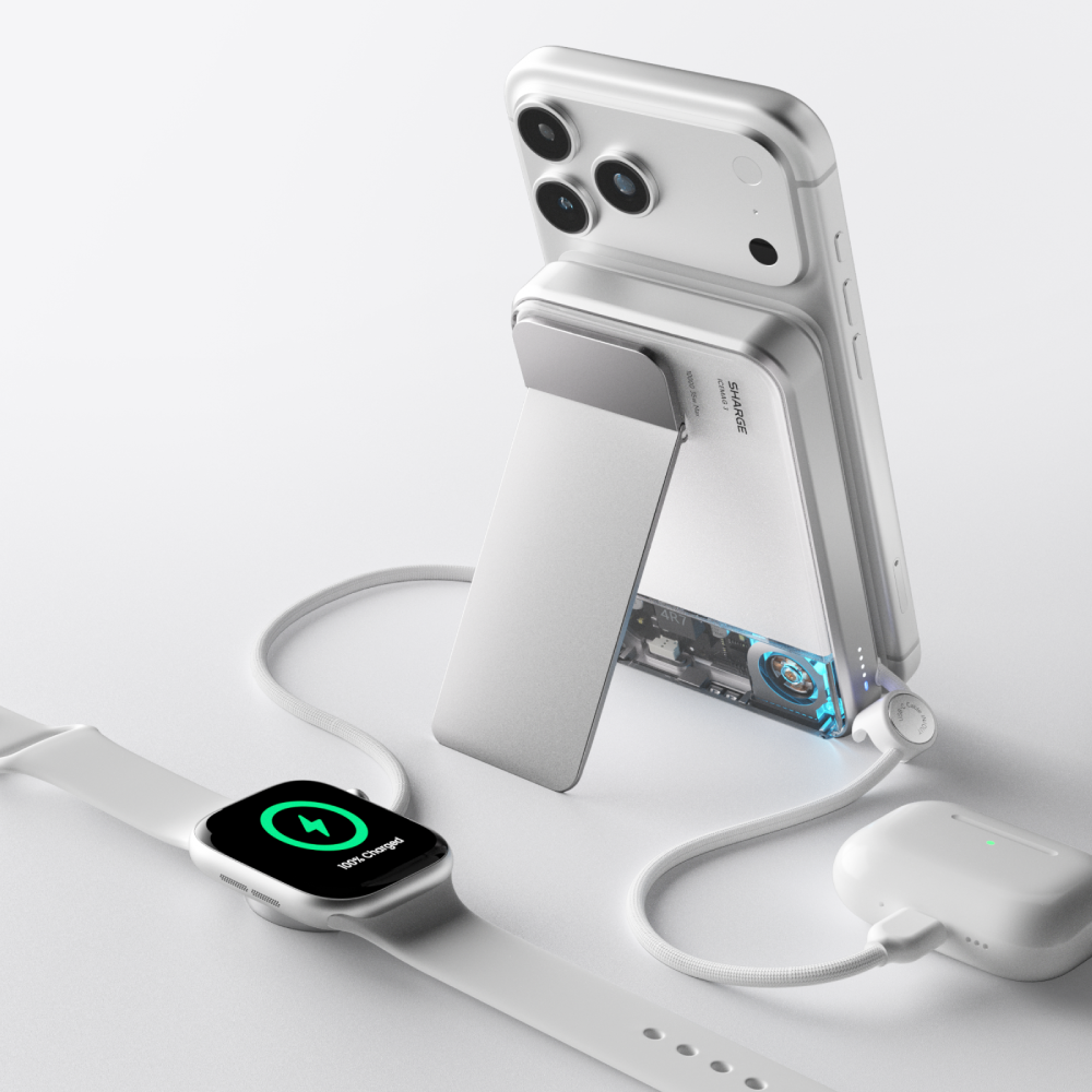 Un iPhone blanc tenu par un support, à côté une Apple Watch et charge d'AirPods.