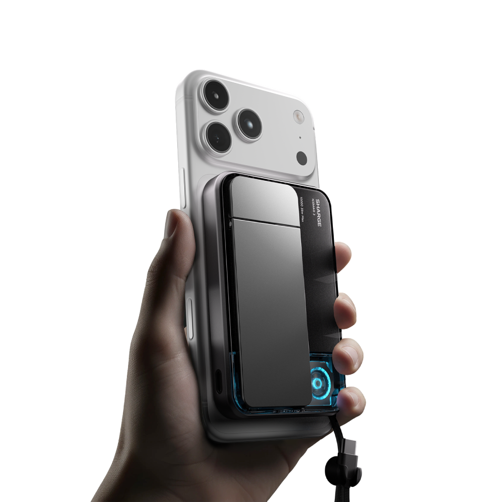 Une main tient un iPhone blanc avec une batterie externe noire attachée.