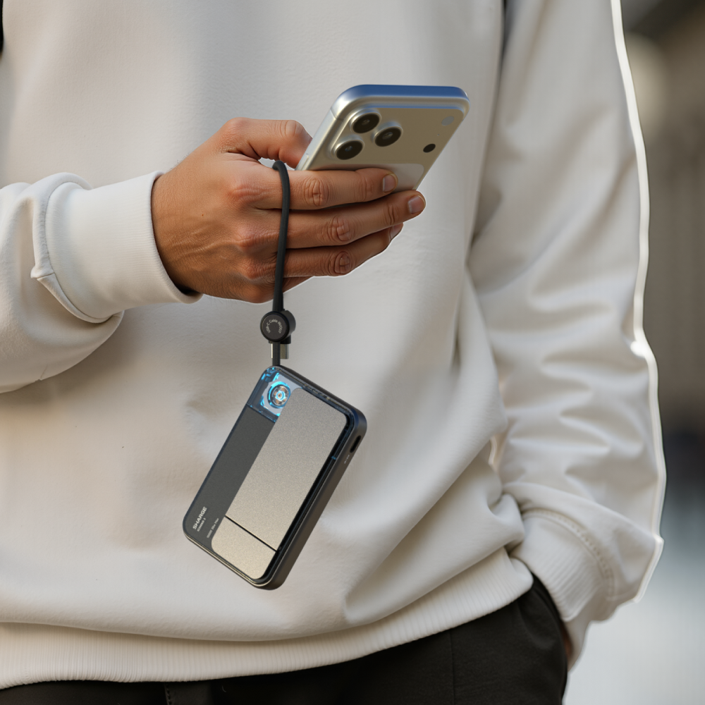 Personne tenant un téléphone avec une lanière et une batterie externe.
