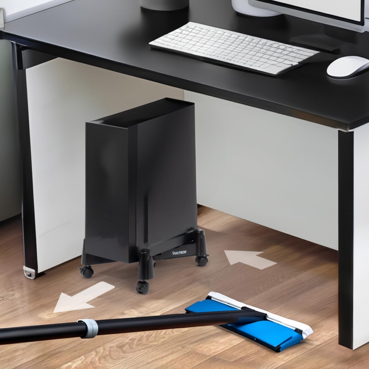 Un mocio pulisce sotto una scrivania con un PC tower su ruote.