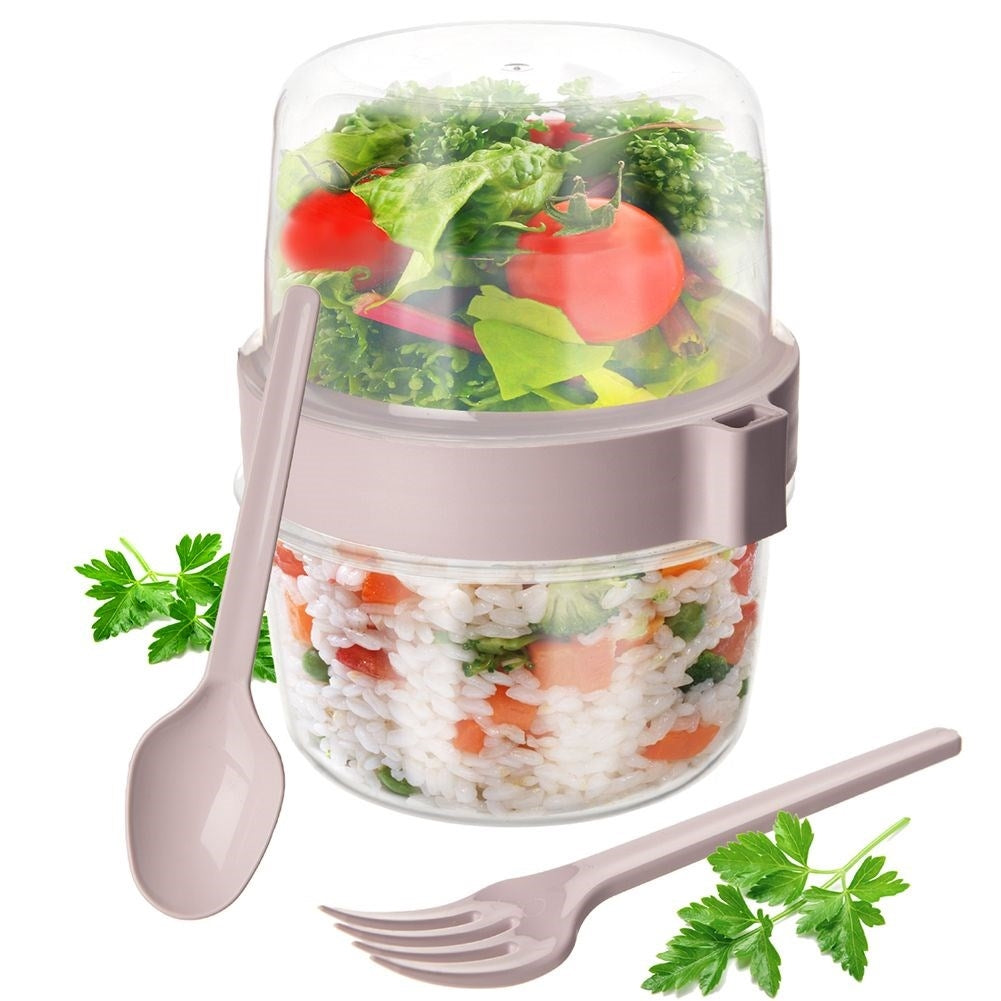 Un recipiente para ensalada con arroz y verduras abajo, ensalada arriba, cuchara y tenedor al lado.
