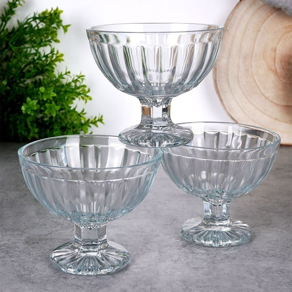 Tres copas de postre de cristal transparente con estrías verticales.