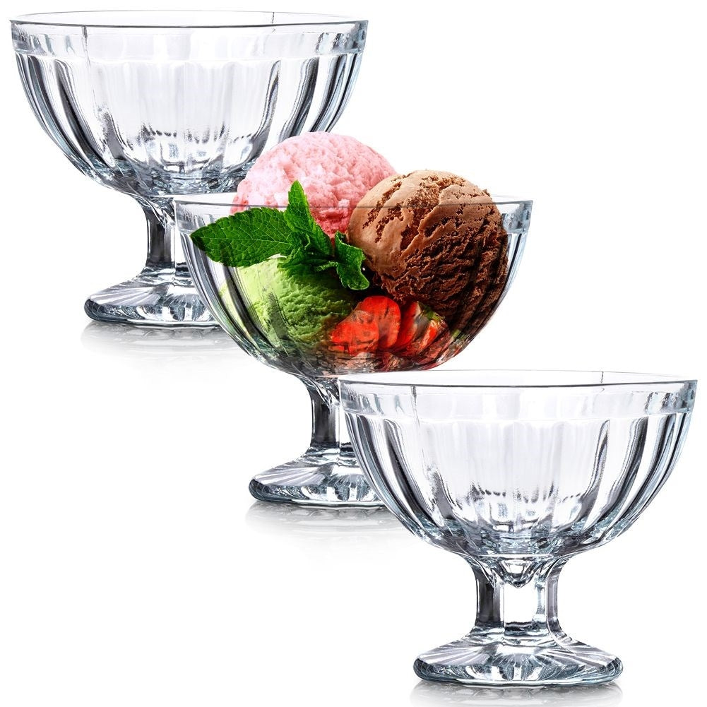 Tres copas de helado de cristal. Una llena de helado verde, rosa y chocolate, fresas y menta.