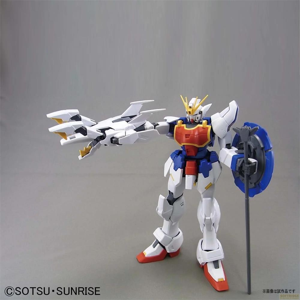 Un robot blanc, bleu et rouge tenant un bouclier et une arme se tient sur fond gris.