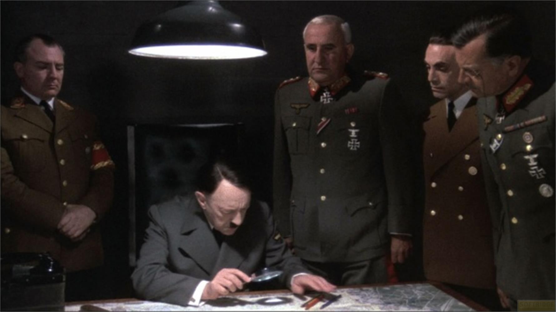 Hitler blickt auf eine Karte, während Militärführer im Raum stehen.
