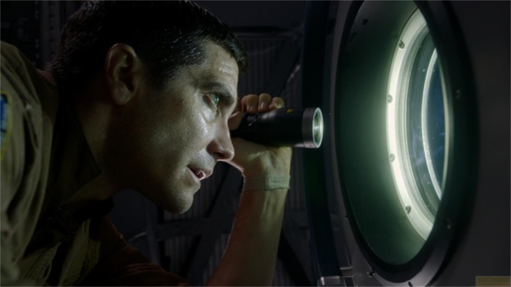 Un uomo guarda attraverso un telescopio una finestra illuminata.