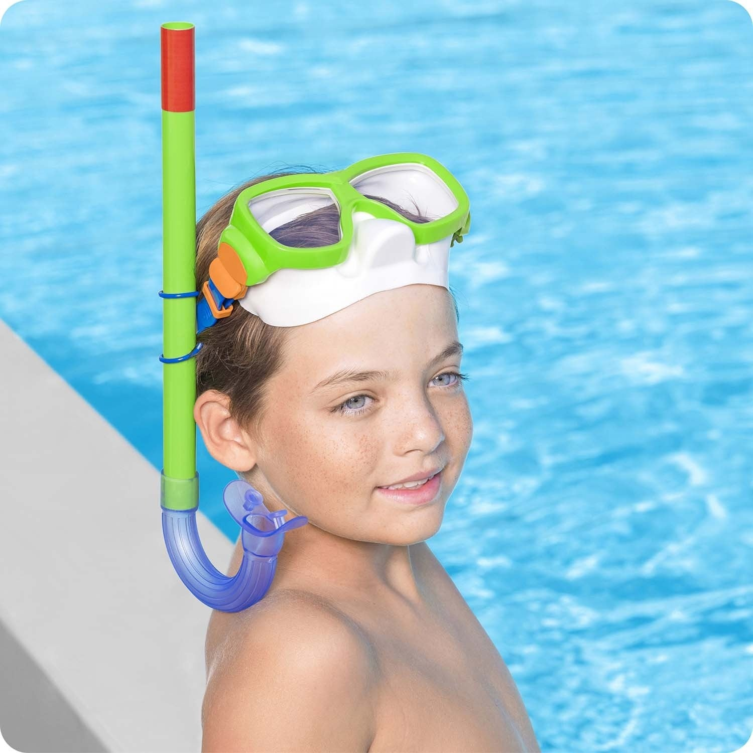 Un niño con esnórquel y máscara junto a una piscina.