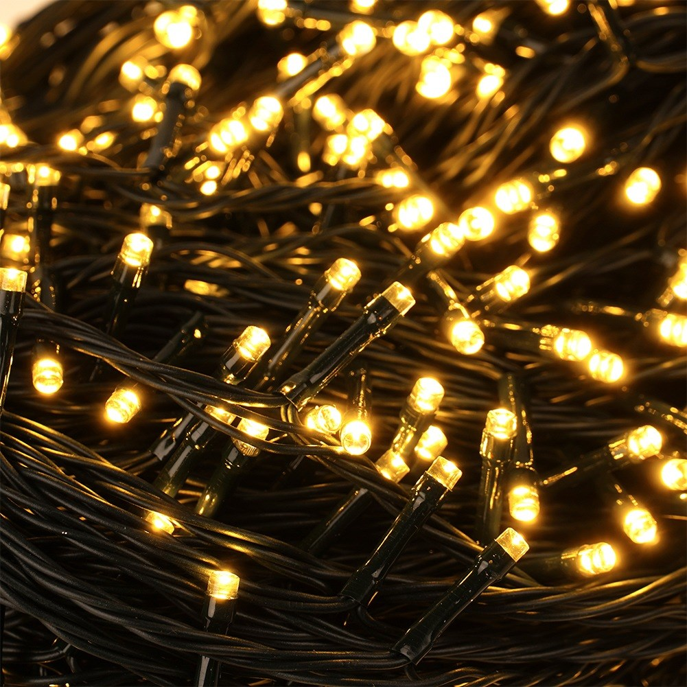 Primer plano de muchas luces de hadas blancas cálidas enrolladas en cables oscuros.