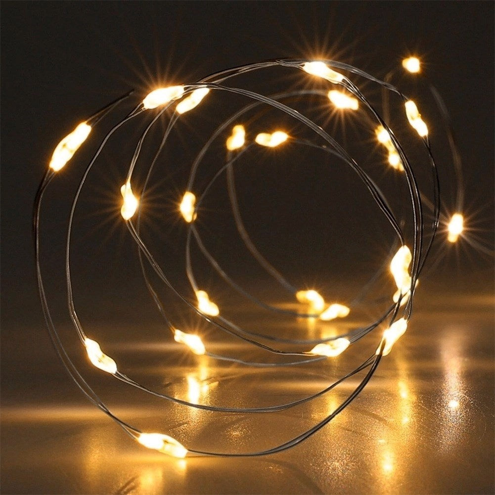 Una catena di lucine con tante piccole luci gialle su sfondo scuro.