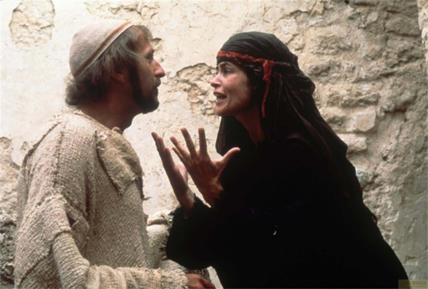 Homme barbu et coiffé parle à une femme voilée de noir.