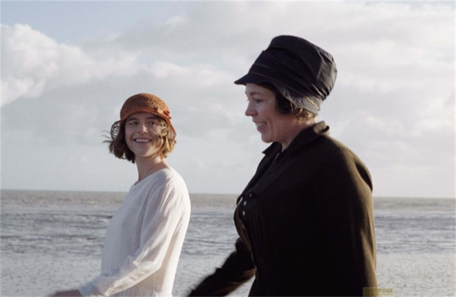 Due donne su una spiaggia, una con cappello arancione, l'altra con cappello scuro.