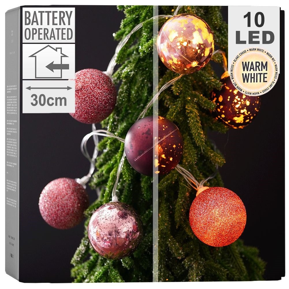 Cadena de luces a pilas con 10 LED blanco cálido en orbes de cristal en un árbol.