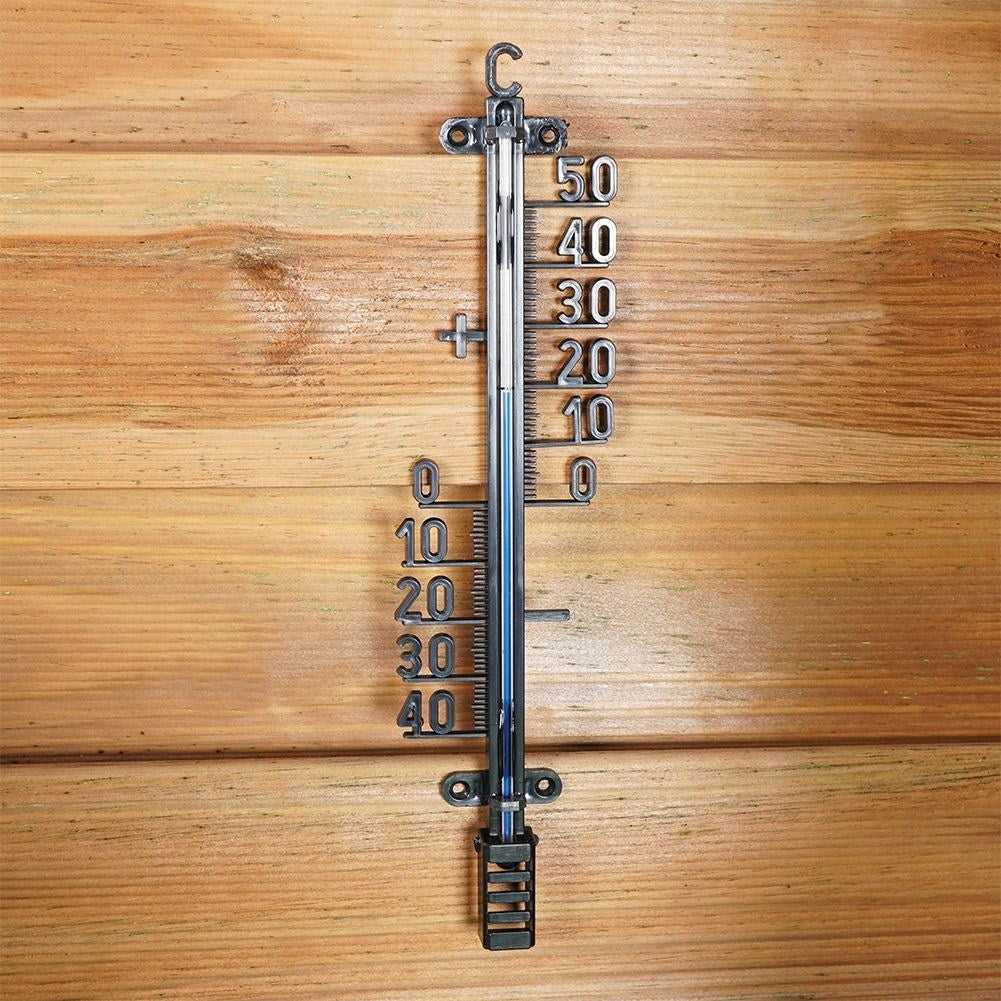 Un termómetro en una pared de madera muestra 22 grados Celsius.