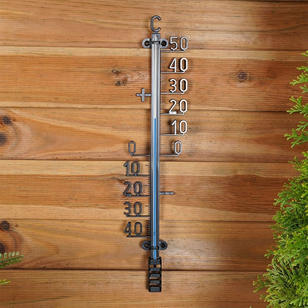 Un termómetro en una pared de madera muestra aproximadamente 15 grados Celsius.