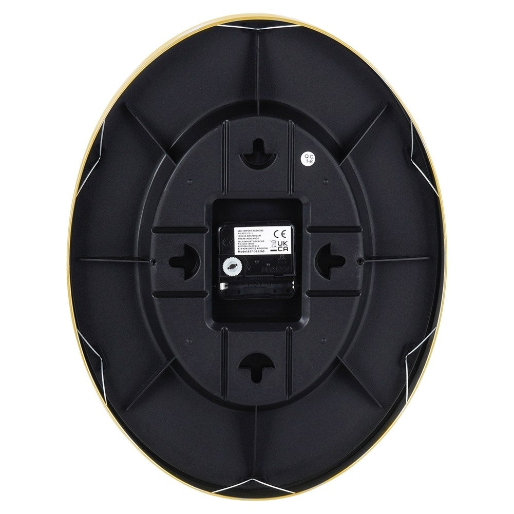 Parte posterior de un reloj ovalado con borde dorado, carcasa negra y movimiento de cuarzo.