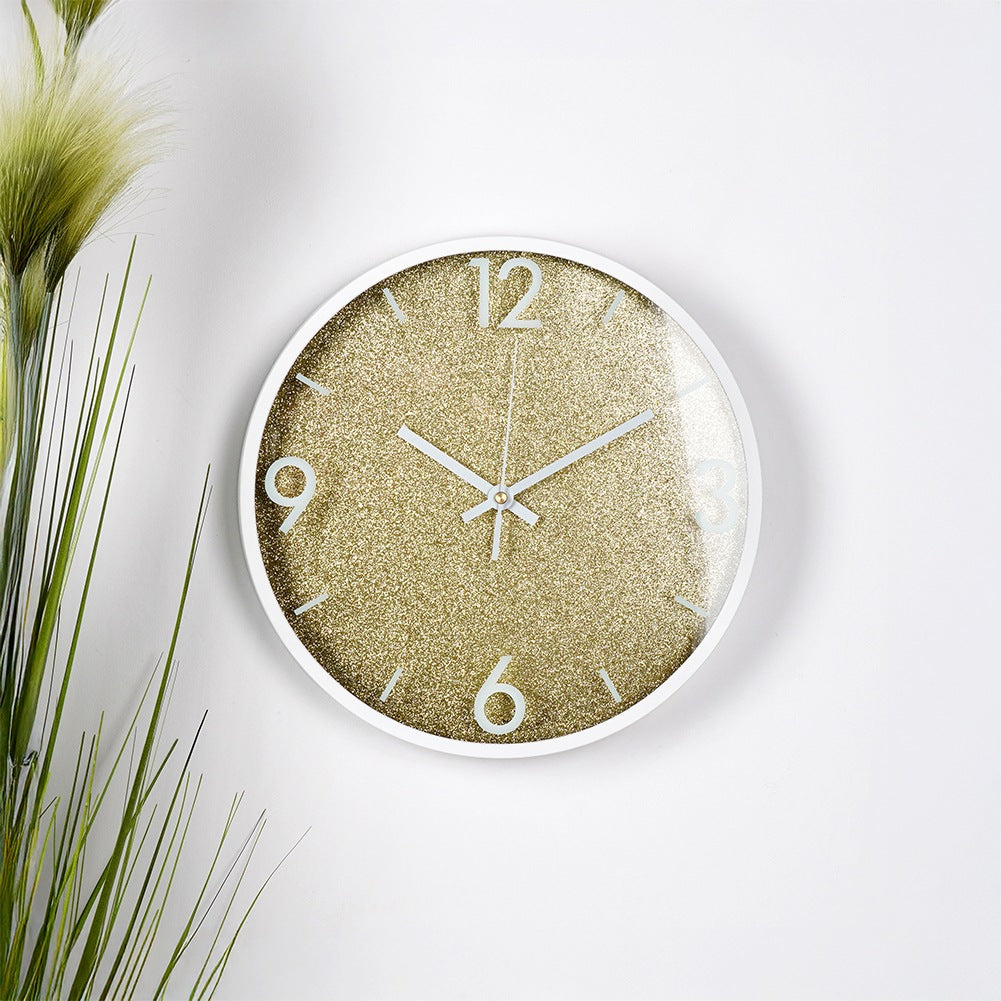 Un reloj de pared blanco con esfera dorada brillante y manecillas blancas.
