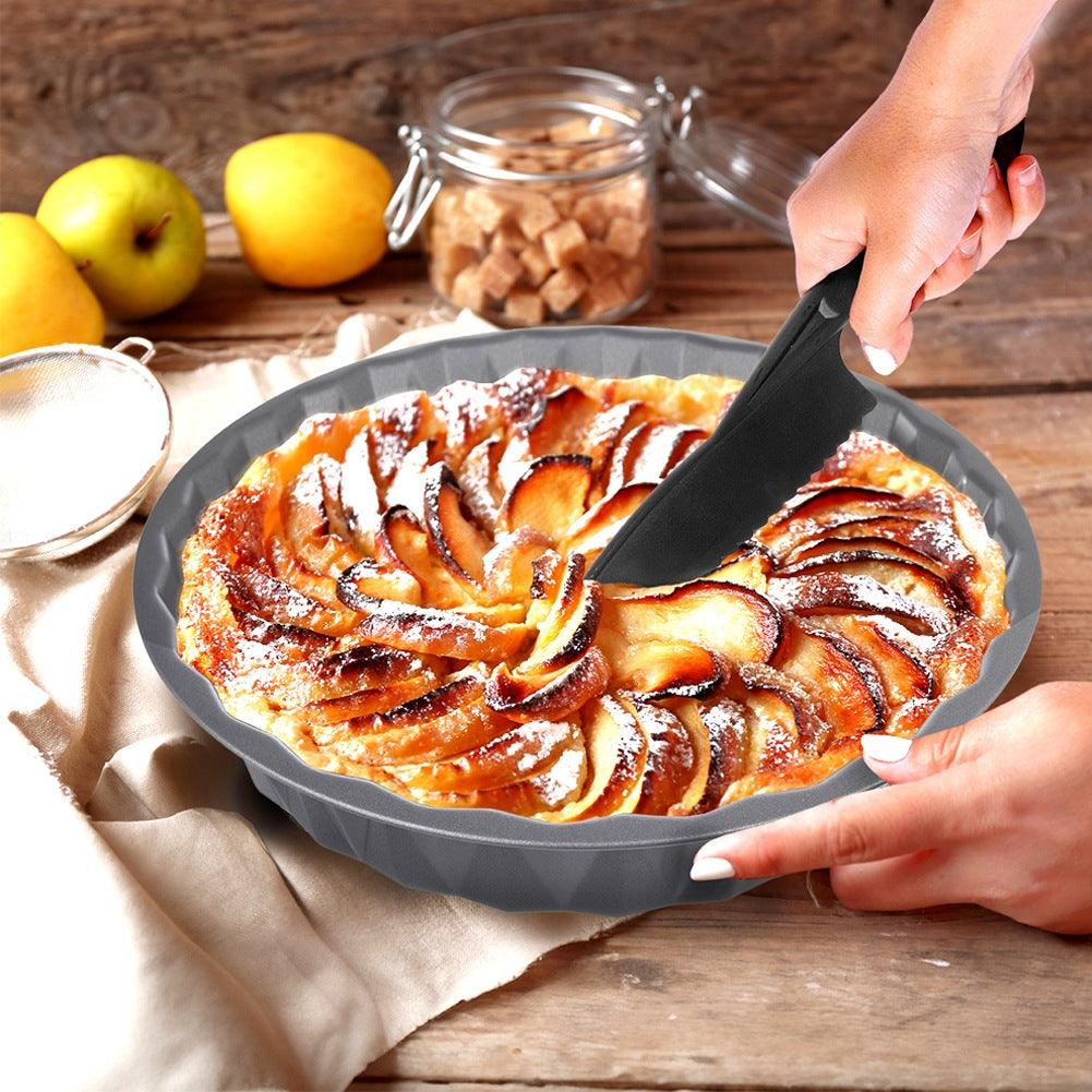 Una persona corta un pastel de manzana con un cuchillo negro. Manzanas cerca.