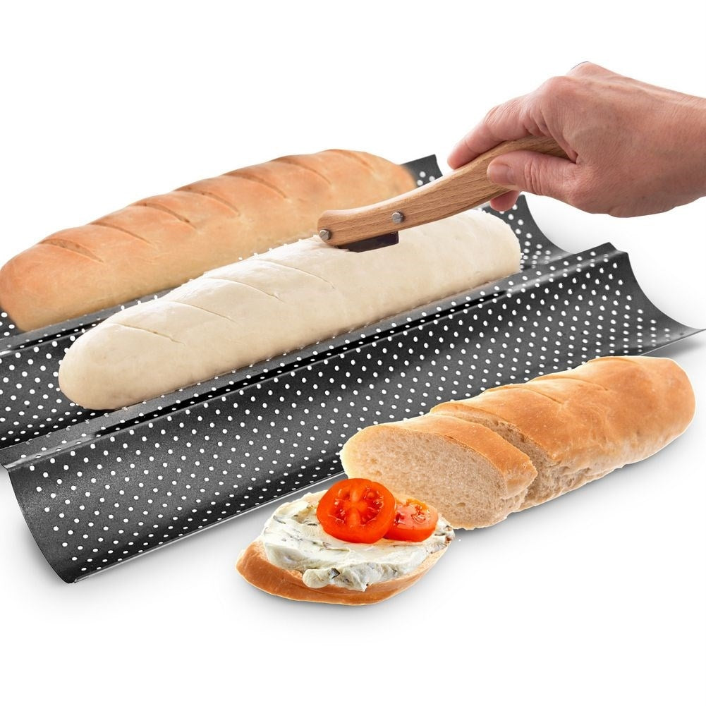 Una baguette se corta en un molde para hornear perforado. A su lado hay baguettes horneadas.