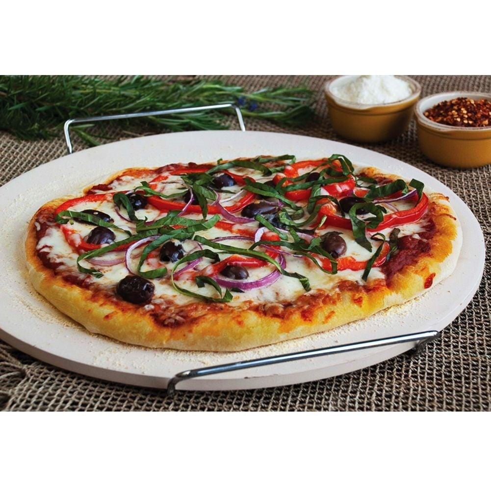 Una pizza con queso, pimientos, cebolla y aceitunas sobre una piedra.
