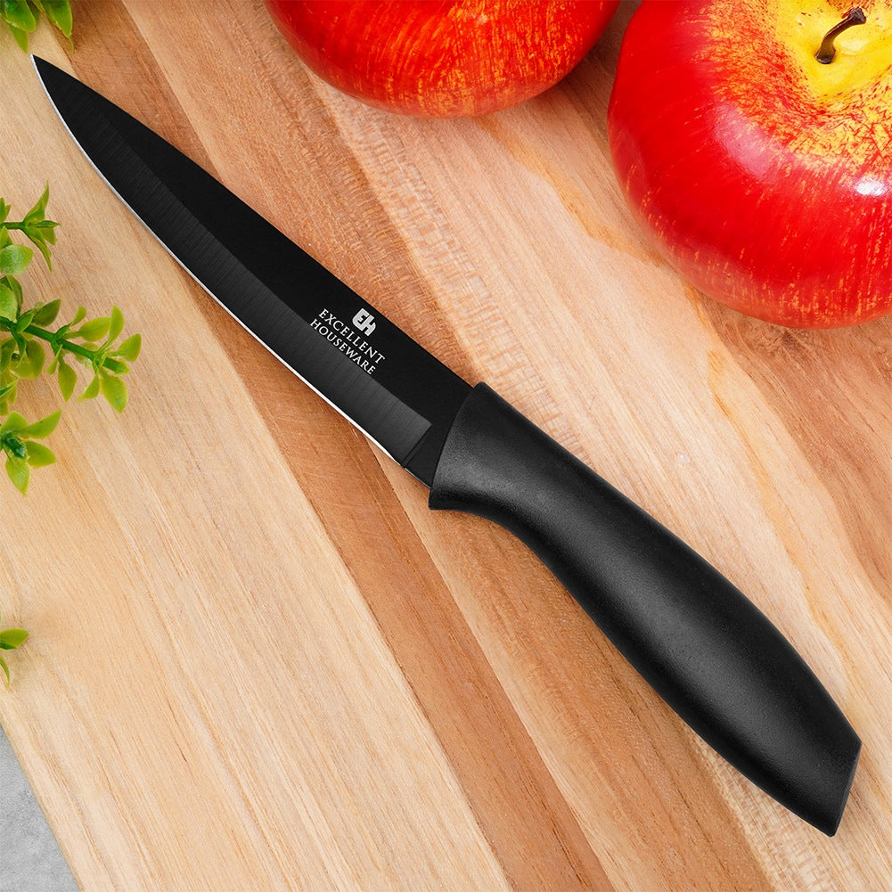 Un cuchillo negro sobre tabla de madera junto a dos manzanas rojas.