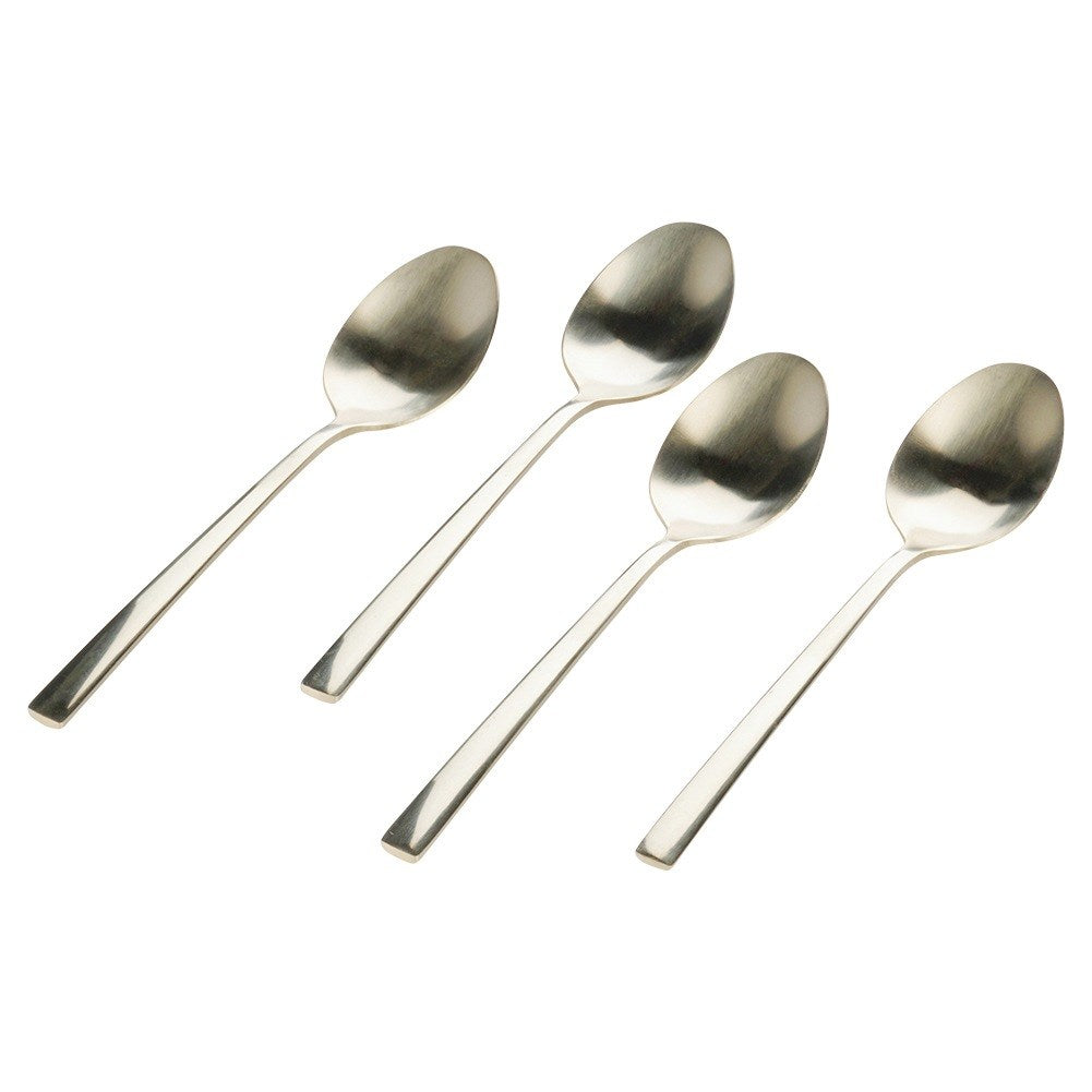 Cuatro cucharas plateadas brillantes yacen una al lado de la otra.