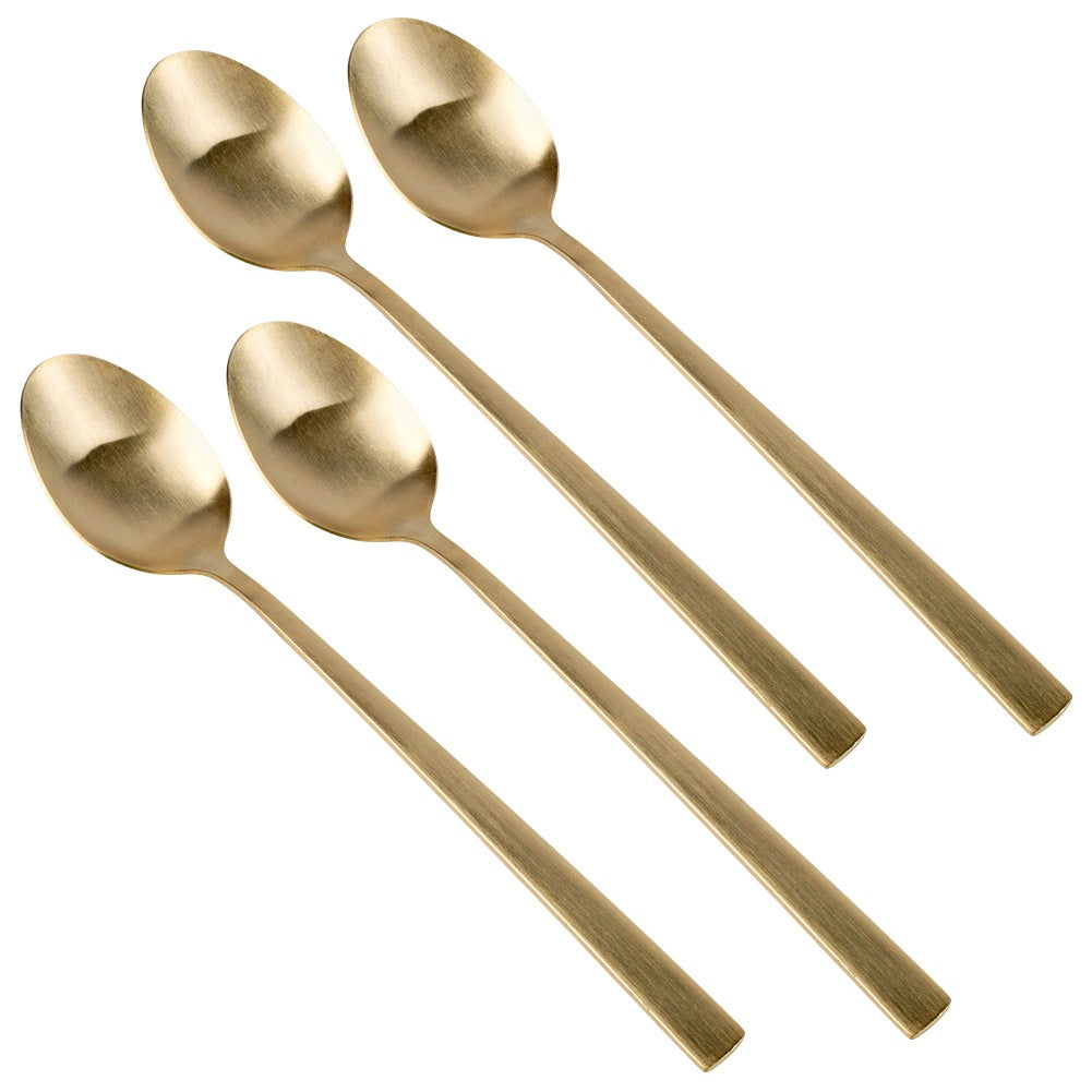 Cuatro cucharas doradas dispuestas en diagonal sobre fondo blanco.