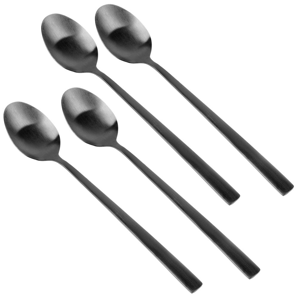 Cuatro cucharas oscuras dispuestas en diagonal sobre fondo blanco.