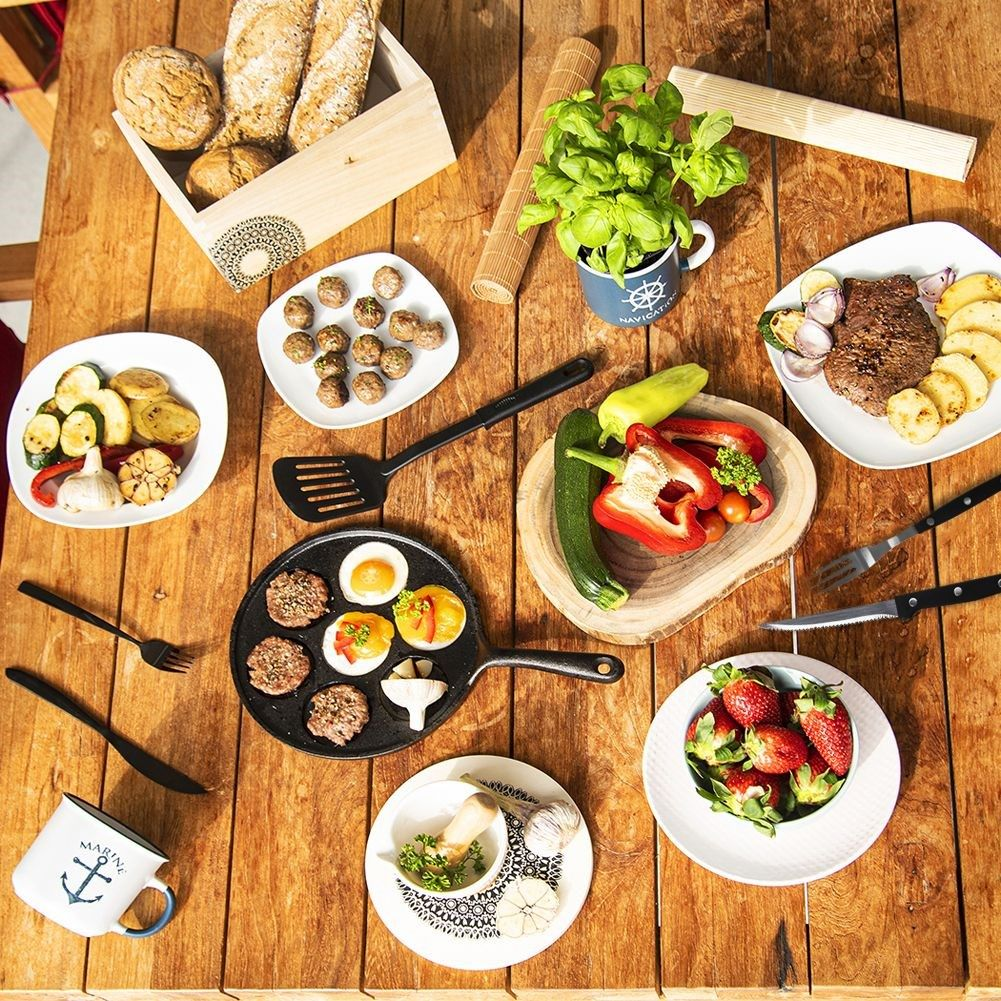 Tabla con comida: carne, verduras, pan, bayas y hierbas.