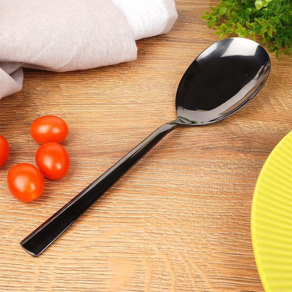 Una cuchara negra descansa sobre una superficie de madera junto a tomates cherry y un paño.