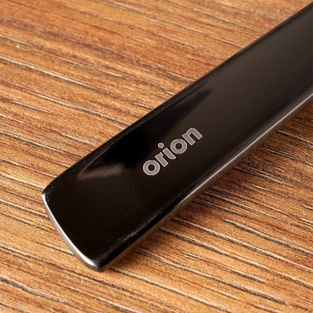 Un objeto negro con la palabra "orion" sobre madera.