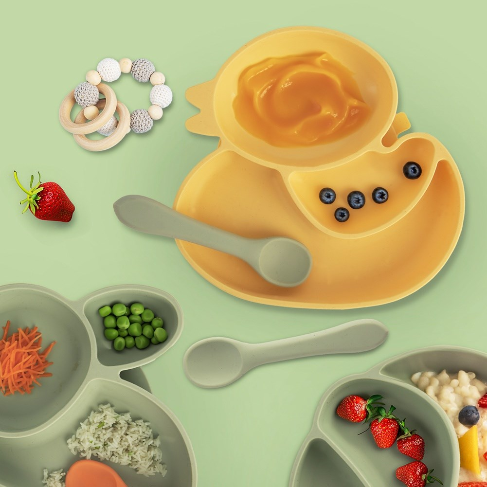 Plato de pato amarillo con puré, arándanos, cuchara, bayas y guisantes.