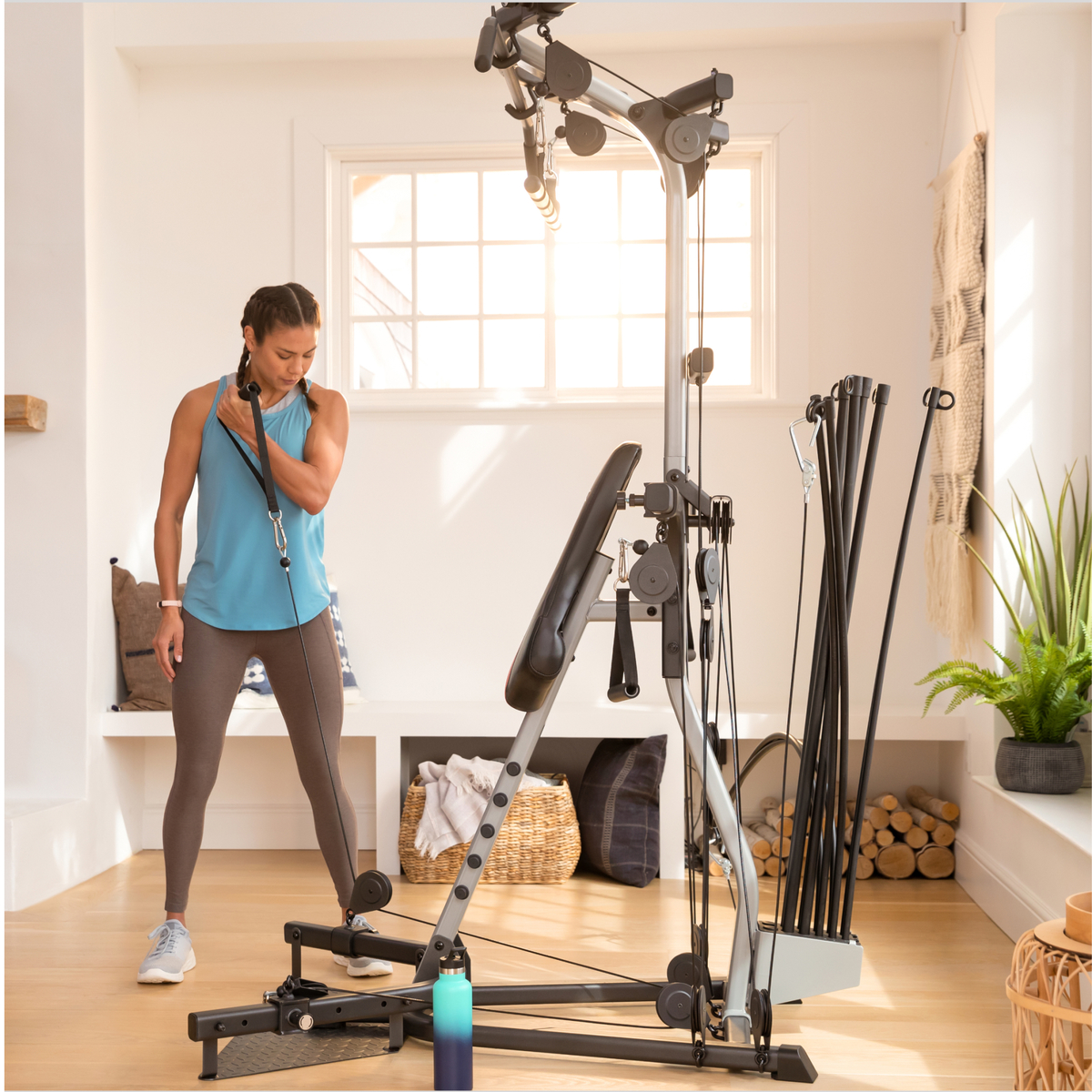 Een vrouw oefent met een homegym in een lichte kamer.