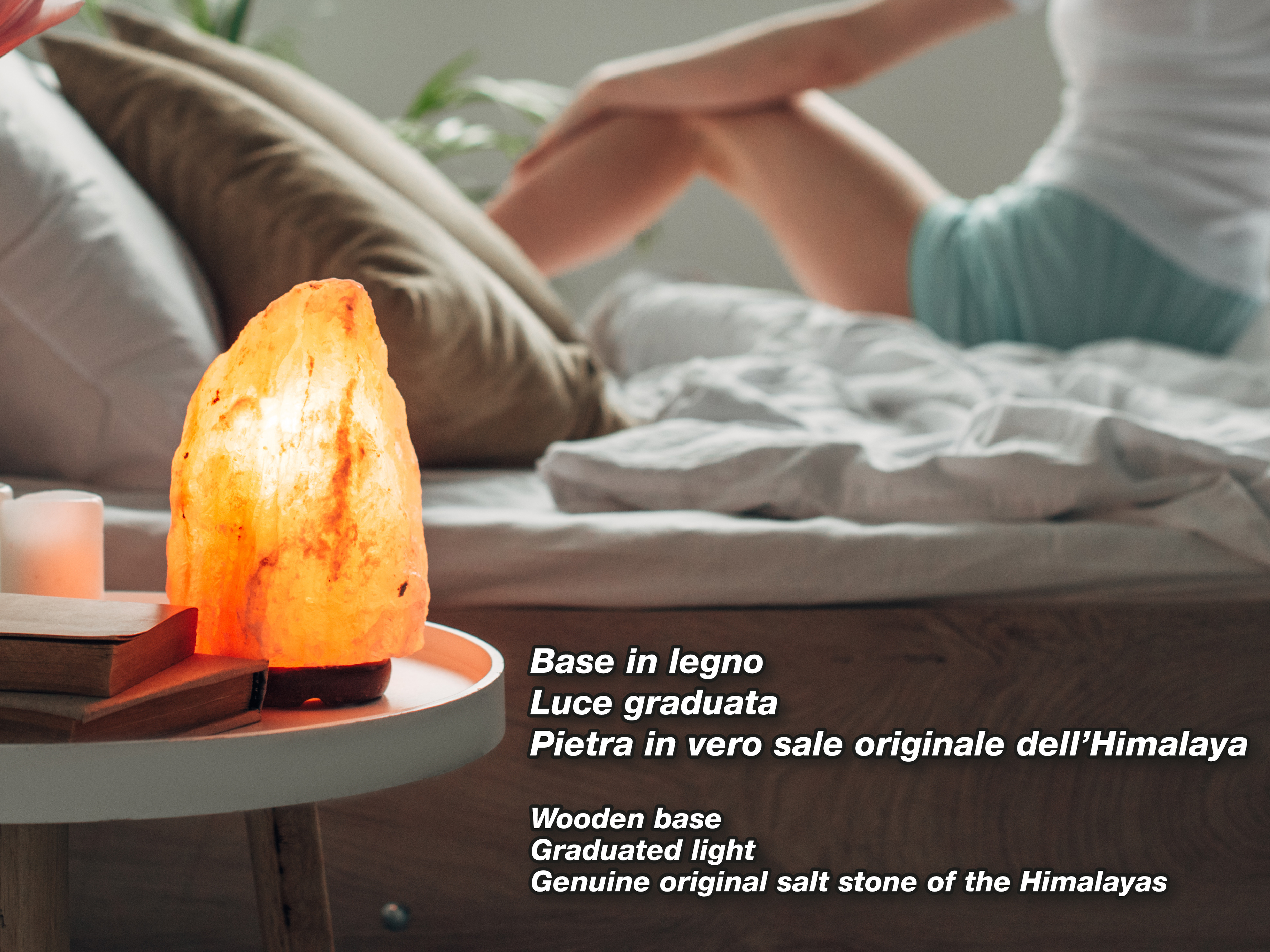 Una pietra di lampada di sale arancione su un tavolo di legno vicino a libri.