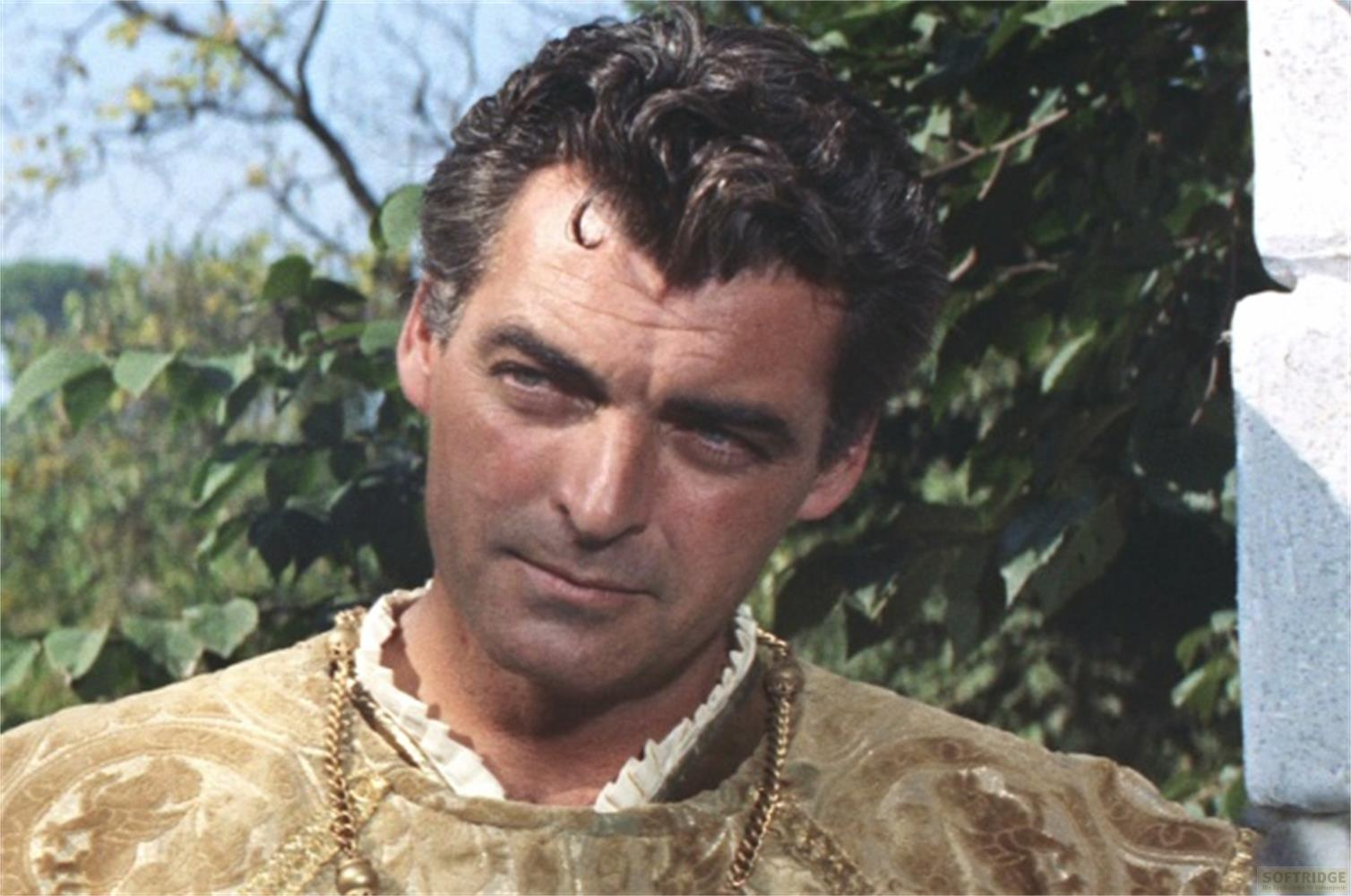Un uomo con capelli scuri e un abito dorato, all'aperto.